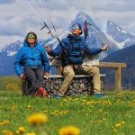 Deux moniteurs de parapente en pause, l’un d’eux contrôle sa voile encore en vol au-dessus de Thollon