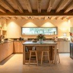 Grande cuisine équipée avec îlot central et poutres apparentes, conception sur-mesure à Annecy par Inova