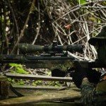 Joueur d’airsoft équipé d’un fusil de sniper en tenue camouflage