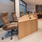 Aménagement d'une salle de conseil avec table en bois sur mesure et fauteuils ergonomiques haut de gamme