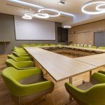 Salle de conférence équipée de chaises vertes ergonomiques et table modulaire par InnoS