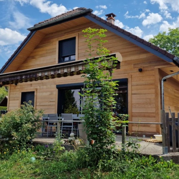 Maison ossature bois écologique avec bardage bois et terrasse, construction réalisée par LBG Charpente