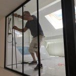 Artisan vitrier posant des vitrages intérieurs dans une pièce en rénovation