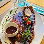 Travers de porc laqués avec sauce barbecue et tomates cerises servis au restaurant Le Redon