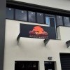 Enseigne extérieure sur auvent pour un garage de véhicules d'occasion installé par SmartCover à Ville-la-Grand
