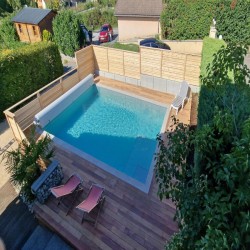 Terrasse bois autour d’une piscine réalisée par le meilleur charpentier à La Roche-sur-Foron (74)