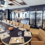 Table élégante dressée devant des étagères à bouteilles dans un bistrot chic