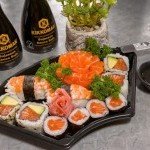Plateau de sushis au saumon et crevette avec sauces soja et gingembre, prêt à être dégusté