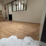 Parquet et carrelage hexagonal associés à une verrière noire, rénovation intérieure à Annemasse par Liberté Patrimoine Rénovation