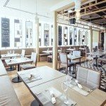 Tables alignées le long d’une banquette moelleuse dans un cadre raffiné