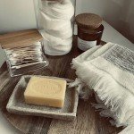 Ambiance spa dans salle de bain : plateau avec savon naturel, serviette roulée et produits bien-être
