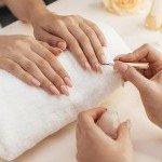 Esthéticienne de chez XXL Coiffure à Annemasse appliquant un vernis semi-permanent nude lors d'un soin complet de manucure spa