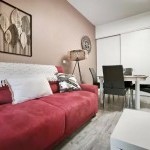 Salon cosy avec canapé rouge, appartement en location courte durée avec Prestige Home Partner en Haute-Savoie