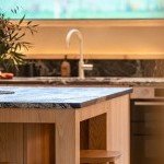 Îlot central en bois et éclairage design pour cuisine sur-mesure à Annecy réalisée par cuisiniste local