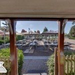 Vue depuis l’intérieur sur la terrasse ensoleillée avec parasols – restaurant La Romana Douvaine