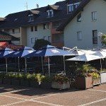 Terrasse fleurie avec parasols du restaurant La Romana à Douvaine – cadre agréable dans le Chablais