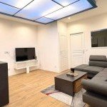 Grand salon moderne avec éclairage design et canapé d'angle, gestion immobilière de luxe en Haute-Savoie