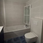 Salle de bains avec baignoire et carrelage clair, rénovation intérieure à Annemasse par Liberté Patrimoine Rénovation