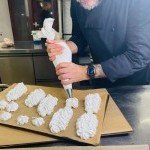Préparation artisanale de meringues dans la cuisine du Coq Rouge, restaurant gastronomique
