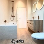 Salle de bains après travaux avec miroirs ronds et meuble en bois, rénovation intérieure à Annemasse par Liberté Patrimoine Rénovation