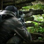 Joueur de paintball dissimulé derrière un abri en bois pendant une partie