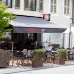 Terrasse extérieure du Full Moon Café avec tables et vue sur Divonne-les-Bains