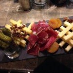 Planche apéro composée de charcuterie et fromages typiques français et espagnols