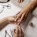 Application précise de vernis semi permanent nude par une esthéticienne de l'onglerie XXL Coiffure à Annemasse